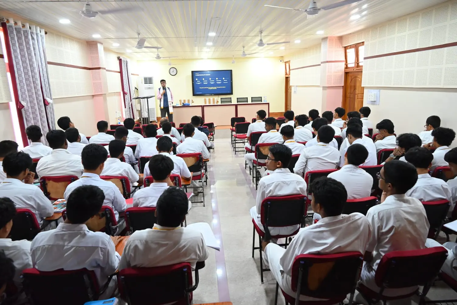 School students in white uniforms listening during a NextChapter Academy career pathway mapping session