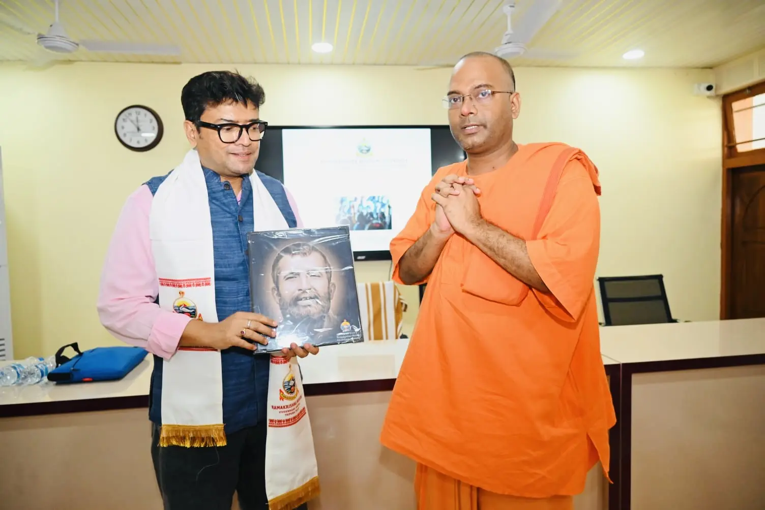 Dr. Jayanta Ghosh receiving a framed portrait from a monk at Ramakrishna Mission Vivekananda Kendra, Agartala