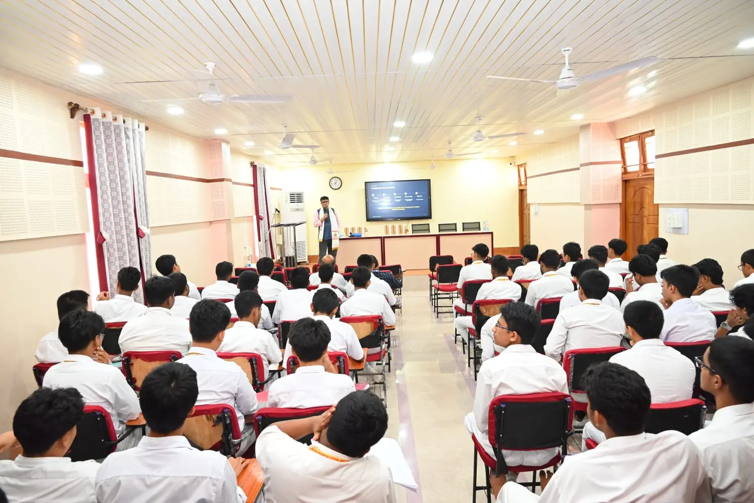 A hall of school students seated attentively during a NextChapter Academy career clarity session in Agartala