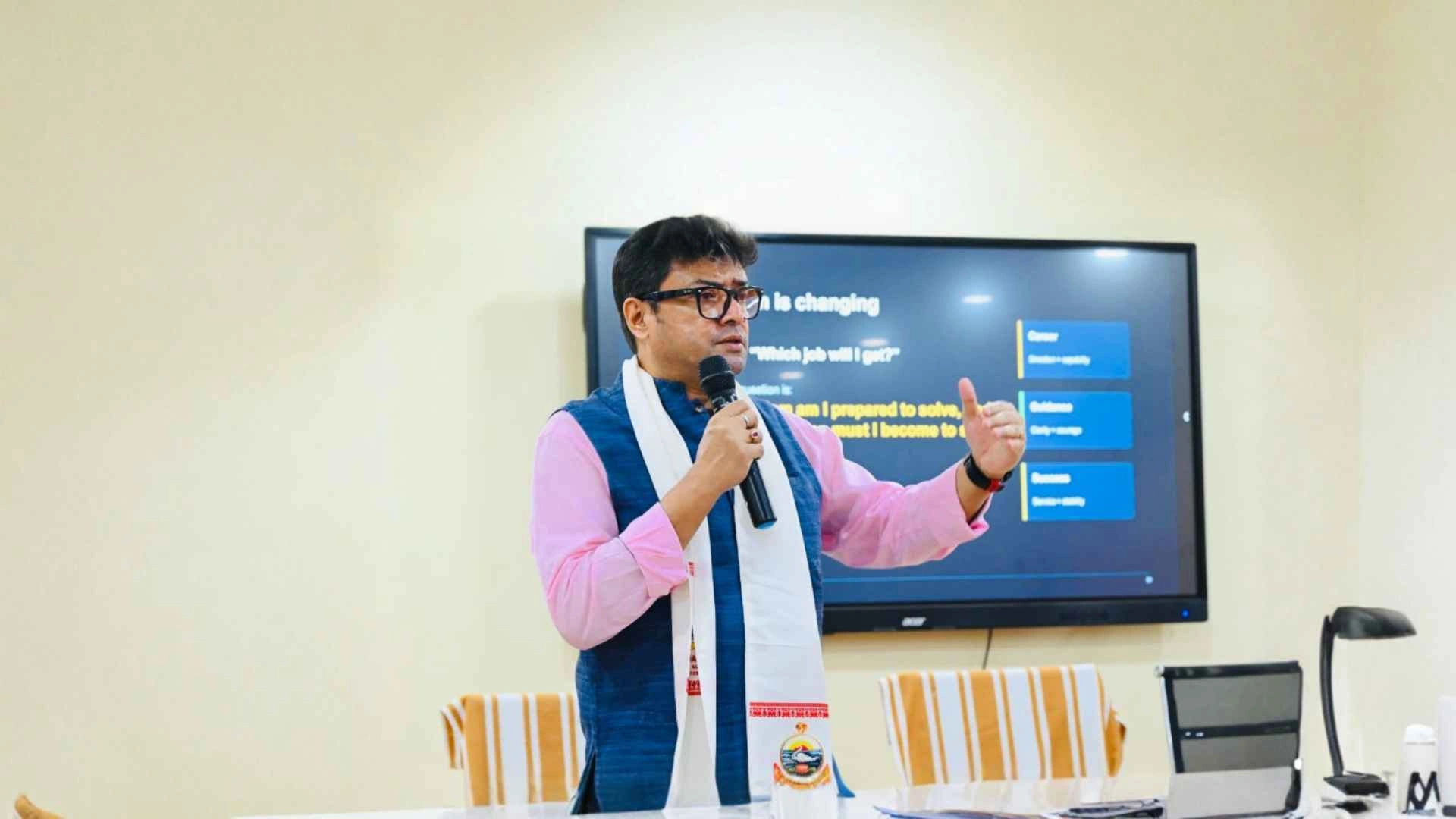 Dr. Jayanta Ghosh leading an interactive session in front of a presentation screen
